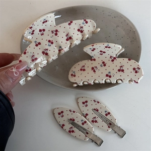 Vue détaillée de pinces à cheveux à motif cerise et barrettes avec petits strass