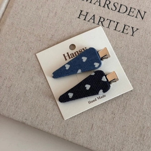 Detail of denim heart pattern hair clips on a card showing blue fabric and metal duckbill clip