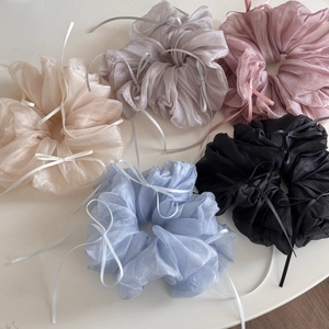 Close-up of five colorful tulle scrunchies with elegant ribbons on white background