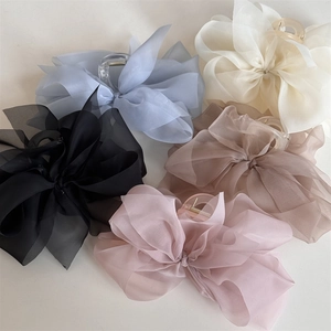 Detail von eleganten Netzschleifen-Haarklammern in Blau, Creme, Schwarz und Rosa