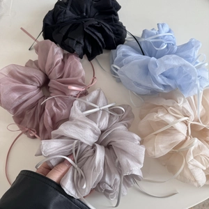 Macro shot of oversized organza hair scrunchies with ribbons in five soft colors