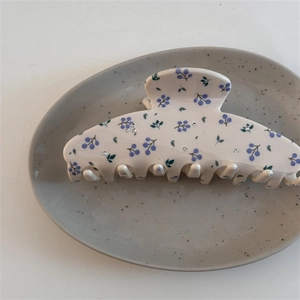 Détail de la pince à cheveux blanche à motif de baies violettes et feuilles vertes