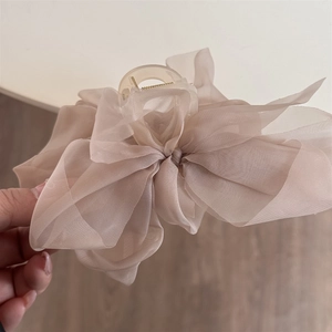 Nahaufnahme einer zarten, hellrosa Organza-Haarklammer mit Schleife für elegantes Styling