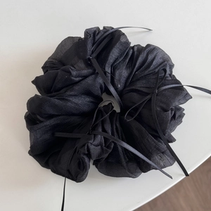 Close-up of black tulle hair scrunchie with ribbons and soft pleated mesh texture