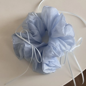 Detail of light blue organza hair scrunchie with delicate white ribbon bows for girls