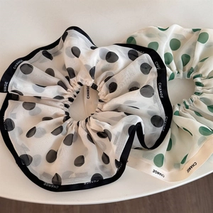 Detail of elegant chiffon polka dot scrunchies with pleated texture and decorative tape