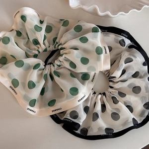 Close-up of elegant chiffon polka dot scrunchies with CHANGE branded ribbons for women