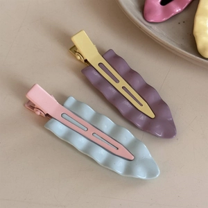 Detaillierte Nahaufnahme gewellter Macaron-Haarspangen in Pastellblau und Rosa