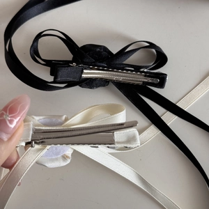 Detail view of the metal duckbill clip mechanism on elegant ribbon bow hairpins