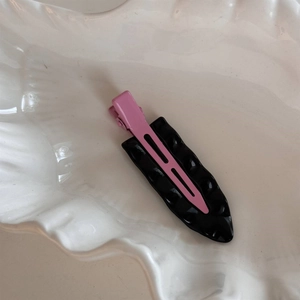 Detailansicht der Haarspange in Pastellrosa mit strukturierter schwarzer Basis aus Harz