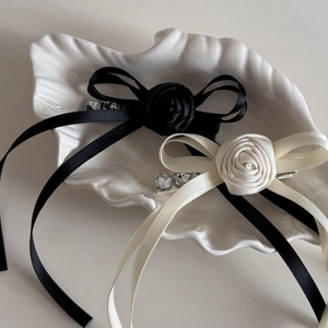 Detailed macro view of satin bow hair clips with rose flowers and sparkling crystals