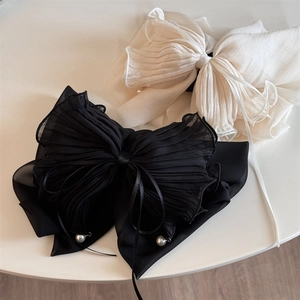 Détail de pinces à cheveux à nœuds en mousseline noir et blanc avec perles douces