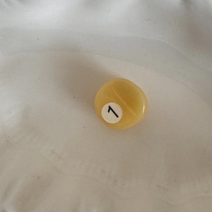 Macro shot of small yellow pool ball hair claw clip in acetate for side fringe styling