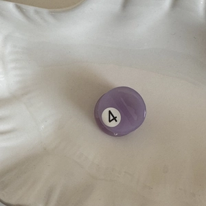 Detail of purple acetate billiards hair claw clip with number 4 design for side fringe