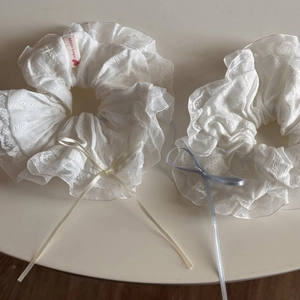 Elegant white lace scrunchies with yellow and blue ribbon bows for stylish hair styling