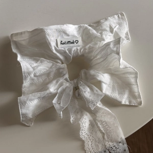 Detail of white lace hair scrunchie with large bow and pearl charm pendant
