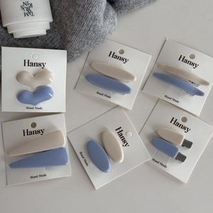 Set di fermagli per capelli in resina opaca nei toni crema e blu con varie forme geometriche