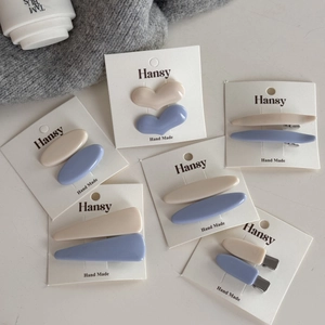Set di 5 mollette per capelli in resina color crema e lavanda su schede di presentazione