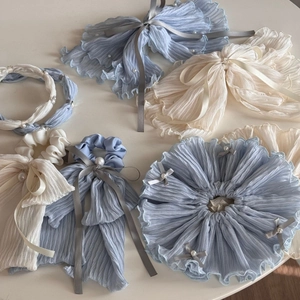 Detailed flat lay of fabric scrunchies with pearls and silk ribbon bow in blue and cream