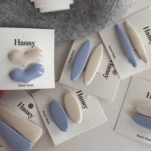 Set di fermagli per capelli blu pastello e crema in varie forme su cartoncini
