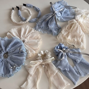 Flat lay of blue and cream oversized fabric scrunchies with pearls and bow details