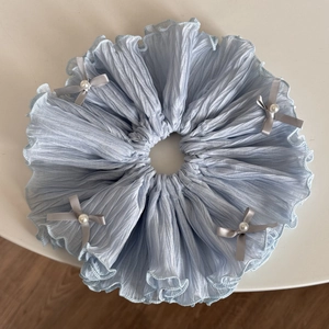Detail of light blue fabric scrunchie with grey satin bows and pearl embellishments