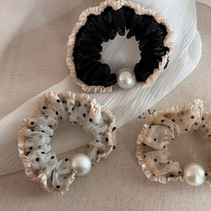Detailed view of mesh hair scrunchies with polka dots, ruffled edges and pearl accents