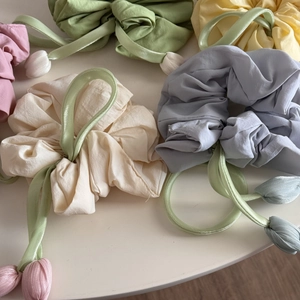 Detailed view of colorful scrunchies with elegant fabric tulip flower pendants