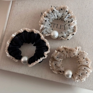 Detail of polka dot mesh hair scrunchies with elegant ruffles and large white pearls
