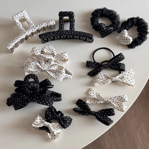 Detailed flat lay of French style black and white polka dot hair clips and accessories
