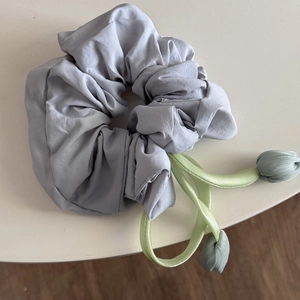 Detail of lavender scrunchie with light green ribbons and tulip pendants for ponytails