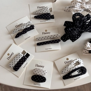 Detailed set of polka dot fabric hair clips and bow headband on a display card