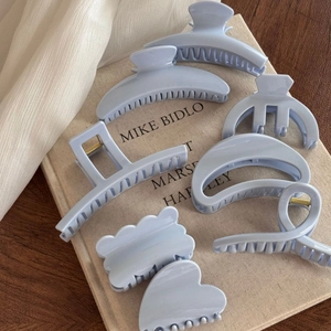 Set of 7 light blue hair claws in various shapes including heart and wave designs