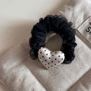 Detail of black organza scrunchie with white polka dot heart charm and mesh texture