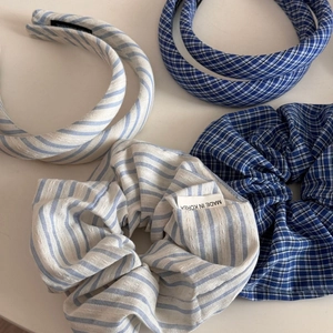 Gros plan de serre-têtes et chouchous en tissu bleu à carreaux et rayures rembourrés