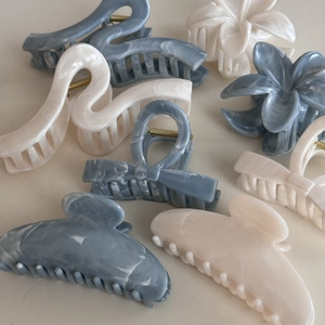 Close-up of assorted acetate claw clips featuring ink texture and marbled patterns