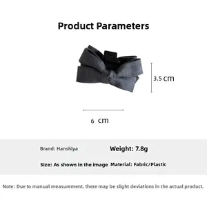 Detail view of a 6cm grey fabric bow hair claw clip with specific size and weight data