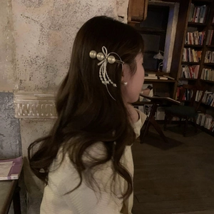 Elegant silver bow hair clip with pearls shown on model in a classic aesthetic style