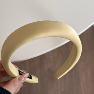 Dettaglio del cerchietto spesso in raso giallo con etichetta fatta a mano pregiata
