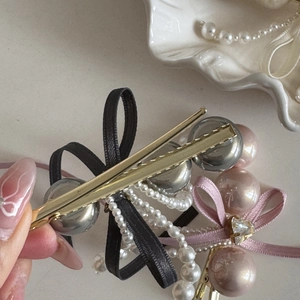 Detail of elegant bow hair clips with tassels, artificial pearls and rhinestone accents