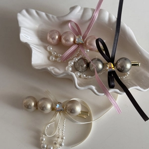 Close-up of pearl bow hair clips with hanging tassels and sparkling rhinestones