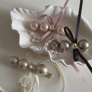 Detail view of three French vintage bow hair clips with pearls and heart rhinestones