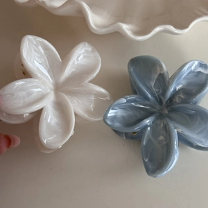 Detail of flower hair clips with marble texture in cream and blue for thick hair