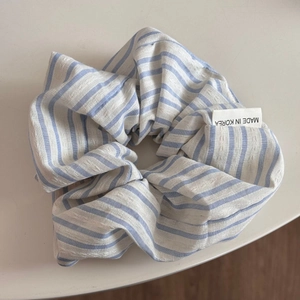 Détail d'un chouchou à rayures bleues et blanches avec étiquette tissée Made in Korea