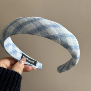 Détail d'un serre-tête éponge à carreaux bleus et blancs avec étiquette Hand Made