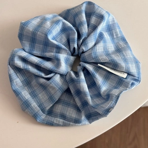 Gros plan détaillé du chouchou à carreaux bleus avec étiquette Made in Korea