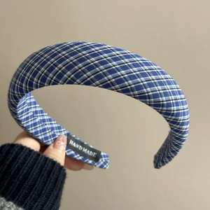 Détail du serre-tête à carreaux bleus avec étiquette fait main cousue sur le côté interne