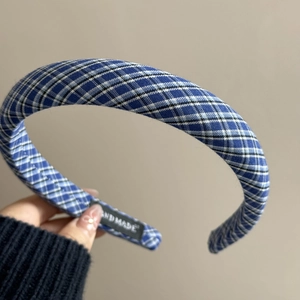 Détail du serre-tête en tissu à carreaux bleus avec étiquette faite main tissée à l'intérieur