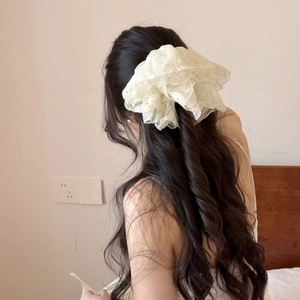Chouchou géant en dentelle blanc crème sur cheveux ondulés, style français élégant