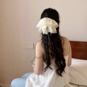 Chouchou géant en dentelle blanc crème avec volants superposés porté sur cheveux longs